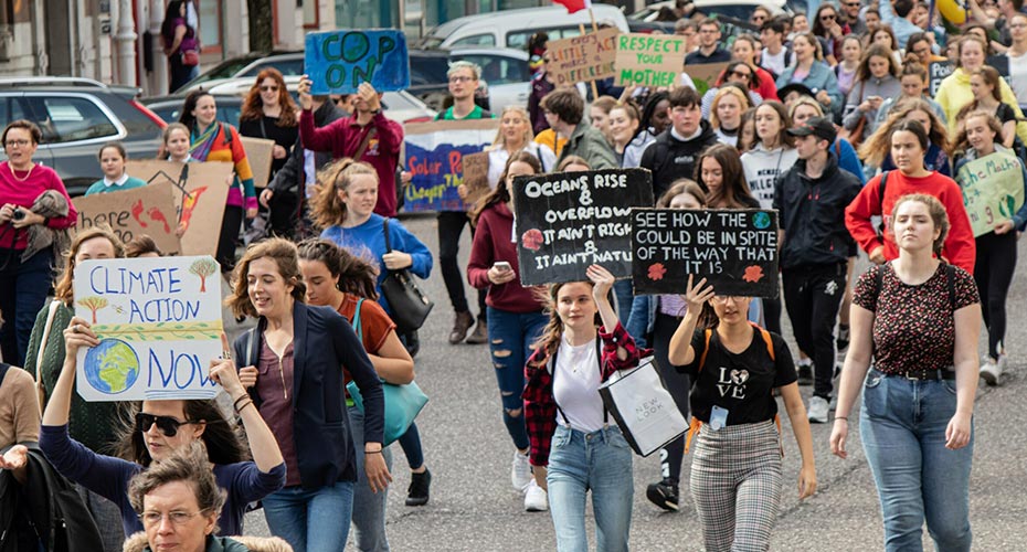 © Robin Erino/Pexels Junge Menschen halten während einer Klimademo Schilder mit ihre Forderungen hoch.