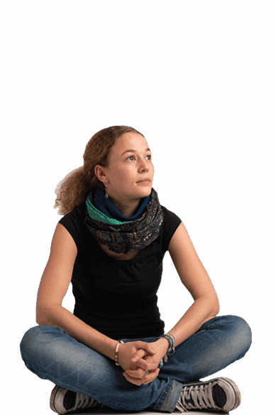 Eine Jugendliche aus Deutschland sitzt auf dem Boden und blickt nach oben.