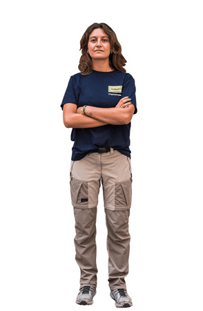 Eine Seenotretterin sieht mit verschränkten Armen und entschlossenem Blick in die Kamera.