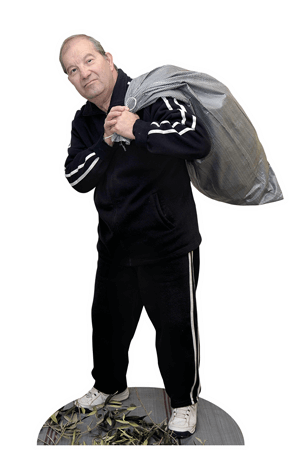 Ein griechischer Olivenbauer trägt einen großen Sack auf dem Rücken.