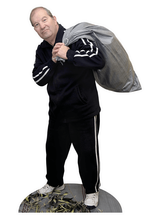 © Ria Papadopoulou Ein griechischer Olivenbauer trägt einen großen Sack auf dem Rücken.