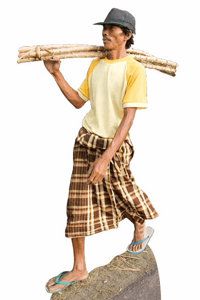 Ein Holzarbeiter aus Indonesien trägt ein Bündel Holz auf der Schulter.