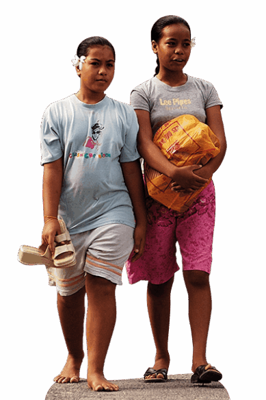 Zwei junge Frauen aus Kiribati sind mit einer Einkaufstasche auf der Straße unterwegs.