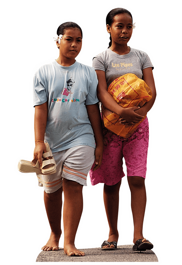 © Specialist Stock Zwei junge Frauen aus Kiribati sind mit einer Einkaufstasche auf der Straße unterwegs.