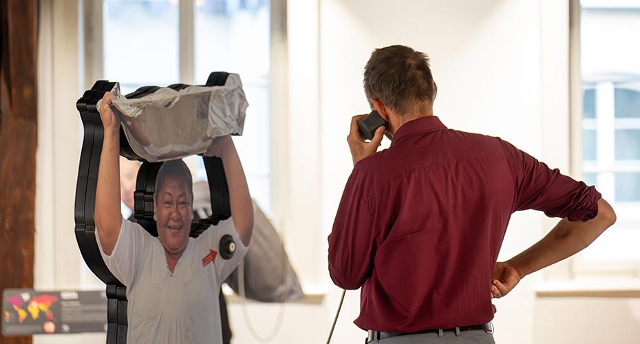 © Uli Jendrass Ein Ausstellungsbesucher hört die Geschichte der Figur aus Tokelau.