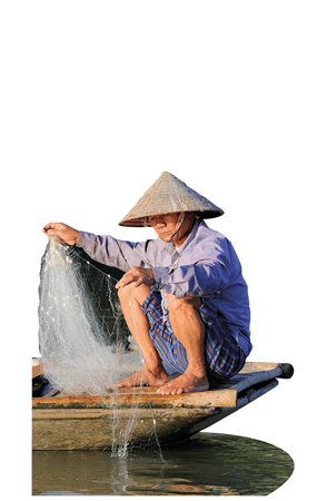 Ein Mann aus Vietnam hockt auf seinem kleinen Boot und holt ein Fischernetz ein.