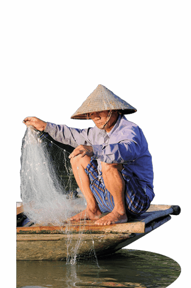 Ein Mann aus Vietnam hockt auf seinem kleinen Boot und holt ein Fischernetz ein.